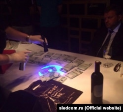 The Investigative Committee shared photographs of Nikita Belykh at a restaurant as investigators shined ultraviolet flashlights at an alleged bribe of 400,000 euros.