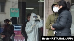 Кина- луѓе со заштитни маски во обид да се спречи ширењето на вирусот