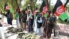 FILE: Former Taliban members hold national flags as they surrender their weapons during a reconciliation ceremony in in the eastern city of Jalalabad in August.