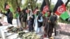 Former Taliban members hold national flags as they surrender their weapons during a reconciliation ceremony in the eastern Afghan city of Jalalabad on August 23.