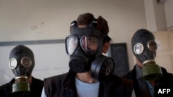 Волонтеры обучают школьников из города Алеппо пользоваться противогазами. 15 сентября