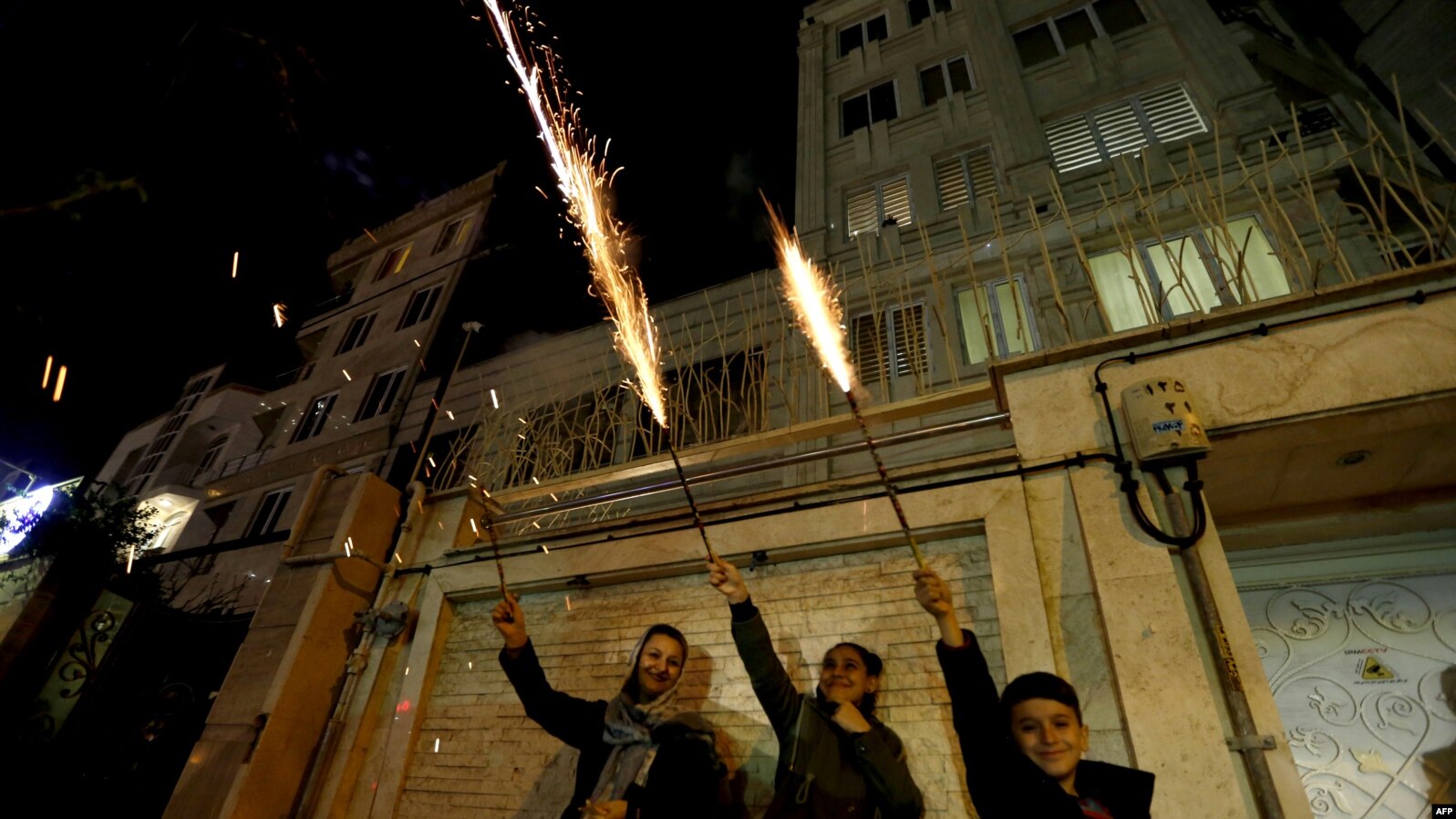 Iranian families light firecrackers outside their houses in Tehran on March 13, 2018 during the Wednesday Fire feast, or Chaharshanbeh Soori, held annually on the last Wednesday eve before the Spring holiday of Noruz. The Iranian new year that begins on