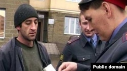 Полицейский в России проверяет документы трудовых мигрантов из Таджикистана.