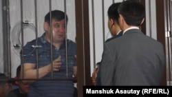 Сол жақта - «Қорғас ісіне» байланысты айыпталушылардың бірі. Алматы, 20 маусым 2013 жыл.