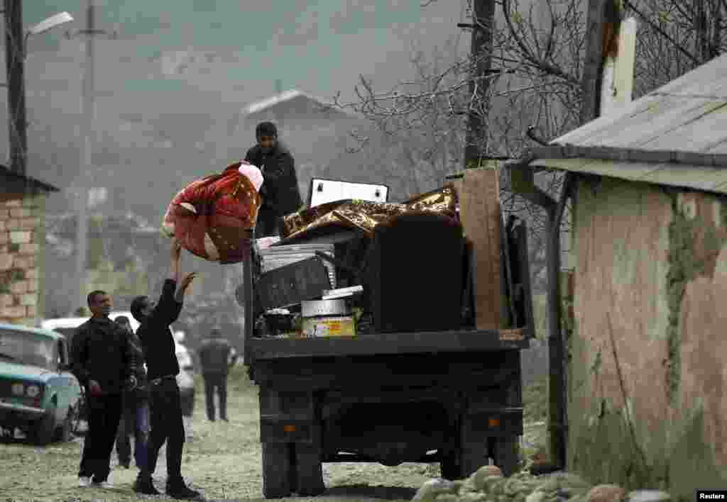 Local residents carry their belongings as they flee from the Nagorno-Karabakh village of Talish on April 6. (Reuters)