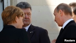 Ukrainian President-elect Petro Poroshenko (center) reacts as Russian President Vladimir Putin (right) speaks with him and German Chancellor Angela Merkel in Benouville, France, during D-Day commemorations on June 6.