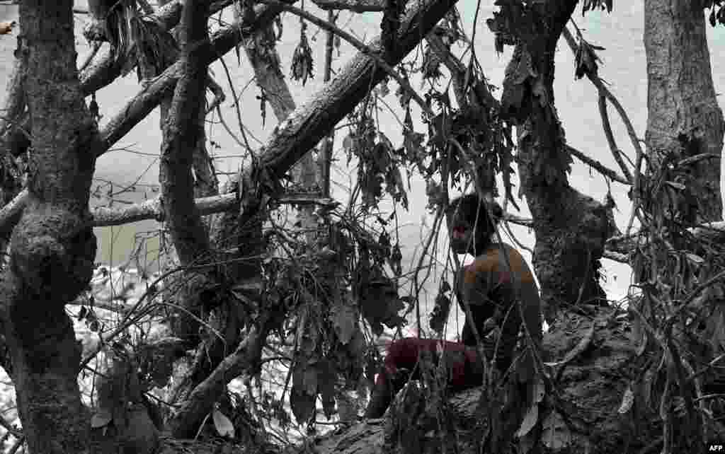 A Nepalese resident looks on at the site of a landslide at Lamo Sanghu villge on the Sukoshi river, some 80 kilometers northeast of Kathmandu. (AFP/Prakash Mathema)