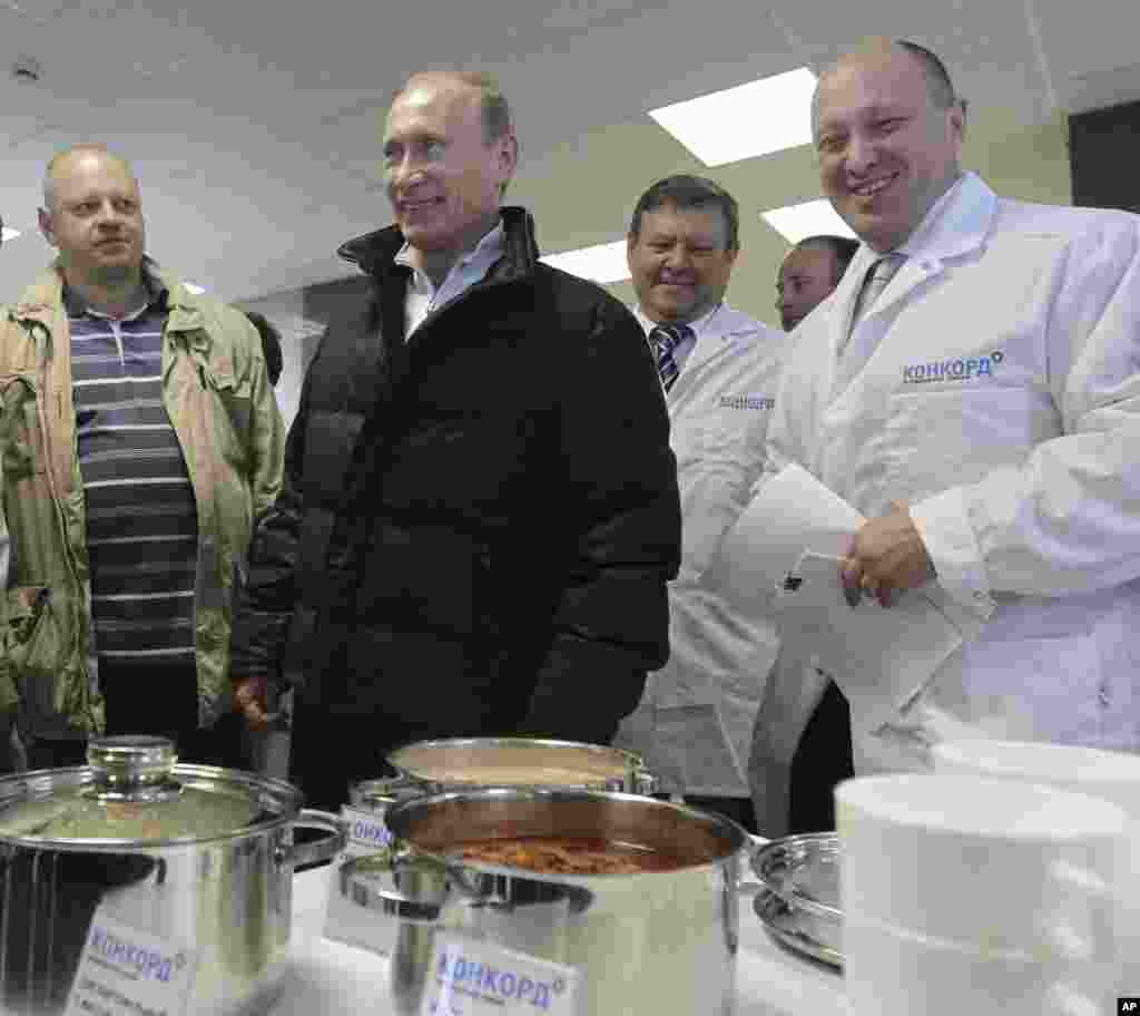 Na ovoj fotografiji od 20. septembra 2010., Prigožin (desno) smješka se dok tadašnjeg ruskog premijera Vladimira Putina (u sredini) vodi u obilazak njegove fabrike koja proizvodi školsku opremu, blizu Sankt Peterburga, Rusija.