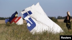 A woman takes a photograph of wreckage at the crash site of Malaysia Airlines Flight MH17 near the village of Hrabove in Ukraine's Donetsk region on July 26.