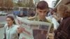 A military cadet pauses to read newspaper coverage of the presidential election at a kiosk in downtown Minsk.