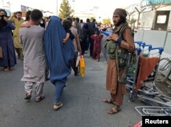 Taliban čuva stražu dok ljudi ulaze na međunarodni aerodrom Hamid Karzai u Kabulu, Afganistan, 16. augusta 2021.