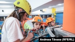 An instructor guides a visually impaired boy along a route in the "adventure area" of the Climb Again center