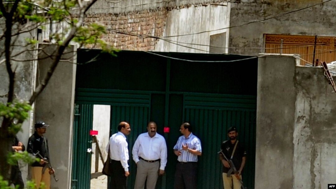 Pakistani security officials gather outside the former hideout of Al-Qaeda leader Osama bin Laden on May 4. The intelligence service called the failure to find bin Laden there "an embarrassment."