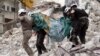 Syrian humanitarian volunteers, known as the White Helmets, carry a body retrieved from the rubble following a reported government airstrike on the town of Ariha, one of the locations mentioned in Amnesty's report. (file photo)