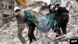 Syrian humanitarian volunteers, known as the White Helmets, carry a body retrieved from the rubble following a reported government airstrike on the town of Ariha, one of the locations mentioned in Amnesty's report. (file photo)