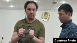 Қолы кісендеулі азаматтық белсенді Нұржан Сембаев сот залында тұр. ActivistsNotExtremists құқыққорғау тобы жариялаған фото