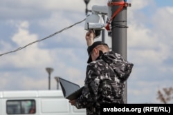 Сілавік настройвае камэру відэаназіраньня ў Менску перад сьвяткаваньнем 9 Траўня, 2021