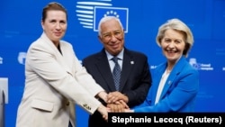 له ښي لوري: د اروپايي ټولنې د کمېشن مشره اورسولا فن دېر لېین، د ټولنې د شورا مشر انتونیو کوستا او د ډنمارک وزیراعظمه مېټا فرېدرېکسن د ډېسېمبر پر ۱۹مه تر سرمشریزې وروسته د خبري غونډې پر مهال یو بل ته لاس ورکوي.