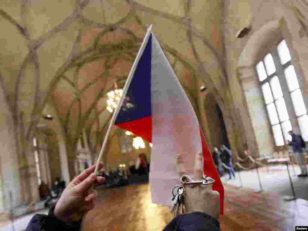 A man waves a Czech flag and a set of keys in homage to Vaclav Havel inside Prague Castle. The jingling of keys, symbolizing the &quot;unlocking of doors,&quot; was a major component of mass demonstrations led by Havel on Wenceslas Square in 1989.