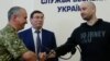 Russian journalist Arkady Babchenko (right) shakes hands with Ukrainian Security Service chief Vasyl Hrytsak (left) as Prosecutor-General Yuriy Lutsenko looks on at a news briefing in Kyiv on May 30.