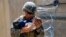 A U.S. Marine assigned to 24th Marine Expeditionary Unit comforts an infant while they wait for its mother during an evacuation at Hamid Karzai International Airport in Kabul at the weekend. 