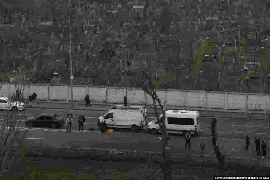 Люди спостерігають за роботою рятувальників, які борються з пожежею в житловій багатоповерхівці, що виникла в результаті російського обстрілу Києва, 29 листопада 2025 року