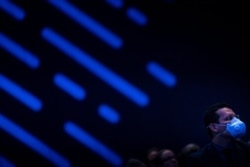 Чоловік у масці проти коронавірусу слухає виступ Ілона Маска на конференції Satellite 2020. Вашингтон, США. 9 березня 2020 року