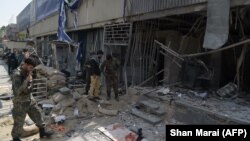 Afghan security personnel inspect the site of a suicide attack outside a bank near the U.S. Embassy in Kabul on August 29.