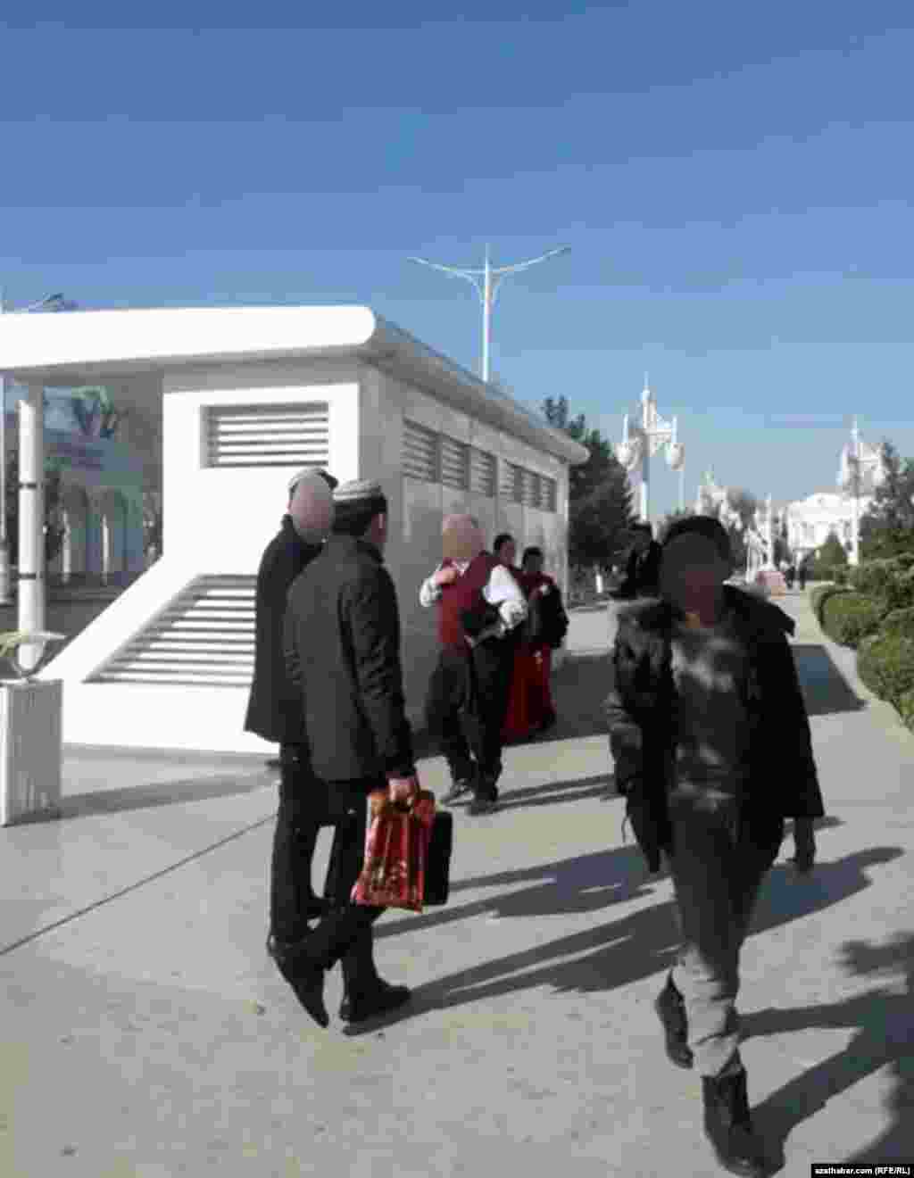 Aşgabatda awtobusyň gelerine garaşyp duran adamlar