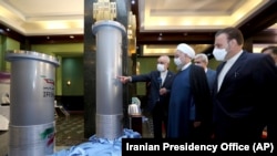 Presidenti iranian Hassan Rohani dëgjon kreun e Organizatës së Energjisë Atomike Ali Akbar Saleh gjatë një vizite të pajisjeve bërthamore të Iranit në Teheran.
