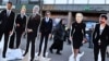 A woman walks past cutouts depicting presidential candidates Yuriy Boyko (left), Yulia Tymoshenko (2nd right), Volodymyr Zelenskiy (right), as well as Russian President Vladimir Putin (2nd left), oligarch Ihor Kolomoyskiy (3rd left) and politician Serhiy Taruta in Kyiv on March 28.