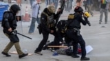 Law enforcement officers detain a protester following multiple detentions by ICE in downtown Los Angeles, California, on June 6. 