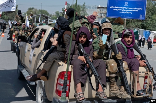 Luftëtarë të armatosur talibanë mbi automjete gjatë një parade, teksa festojnë përvjetorin e parë të tërheqjes së forcave të udhëhequra nga SHBA-ja nga Afganistani, në Kabul më 31 gusht 2022.