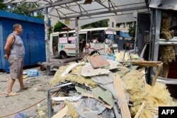 Donețk - un om privește la un autobuz distrus în luptele care au reînceput între forțele guvernamentale și separatiști.