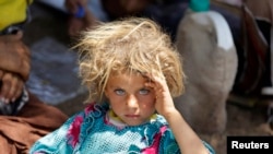 Девочка из семьи езидов во временном лагере беженцев