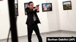Mevlut Mert Altintas, an off-duty policeman, shouts after shooting Andrei Karlov, the Russian ambassador to Turkey (right), at an art gallery in Ankara on December 19, 2016.