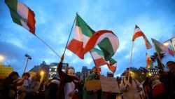 Oamenii flutură steaguri în timpul unei demonstrații de susținere a protestelor din Iran, la Barcelona, ​​Spania, 13 ianuarie 2026.