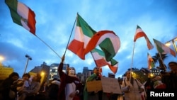 People wave flags during a demonstration in support of the protests in Iran, in Barcelona, Spain on January 13