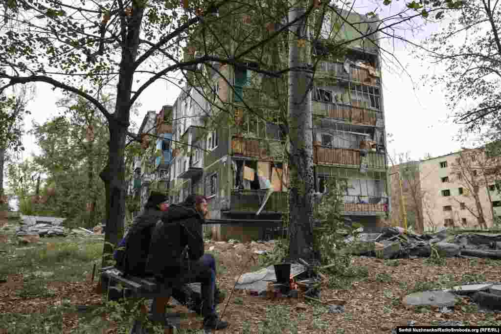 Місцеві жителі Костянтинівки гріють воду на відкритому вогні біля зруйнованих будинків. Костянтинівка, 29 вересня 2025 року.На запитання кореспондента Радіо Свобода про те, чи не страшно залишатися у місті.«Загинути можна скрізь. У мене стільки знайомих виїхало і всі розповідають, що скрізь добре, де нас немає. А так ми хоч у себе вдома. Скільки літніх виїхало і там померло, не витримали. А моїй мамі 83 роки, куди мені їхати ?» – каж один із чоловіків