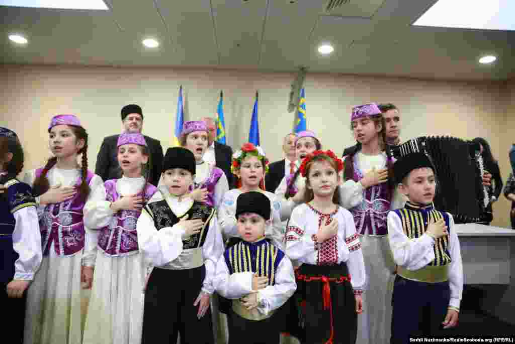 На церемонії вітання звільнених Ільмі Умерова і Ахтема Чийгоза дитячий хор виконав український і кримськотатарський гімни