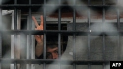 Belarus - A man gestures from a window at a prison , where protesters arrested on December 19 are held, Minsk, 23Dec2010