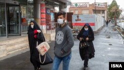 Residents of Qom wear face masks after Iranian authorities reported the deaths of two men in the city.