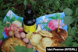 A bottle of kvass, along with eggs, bread, and pies stuffed with ruble coins