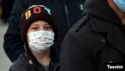Un băiat purtând mască de protecție împotriva coronavirusului