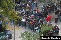 Newly arrived refugees wait on October 9, 2015, to register in Berlin's state office for health and social affairs.