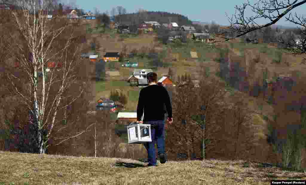 A member of a local election commission carries a mobile ballot box during voting in the village of Kosmach, western Ukraine. (Reuters/Kacper Pempel)