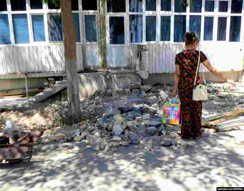 Aşgabatda ýykylan "pristroýkalardan" galan gurluşyk galyndylaryna seredýän gyz.