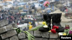 Military boots and flowers are seen at a makeshift memorial for those killed in recent violence in Kyiv on February 25.