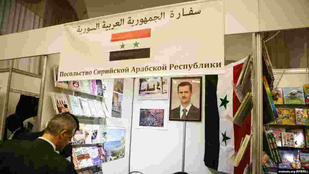 Партрэт Башар Асада суседзіць з прапагандысцкай літаратурай на стэндзе Сырыі