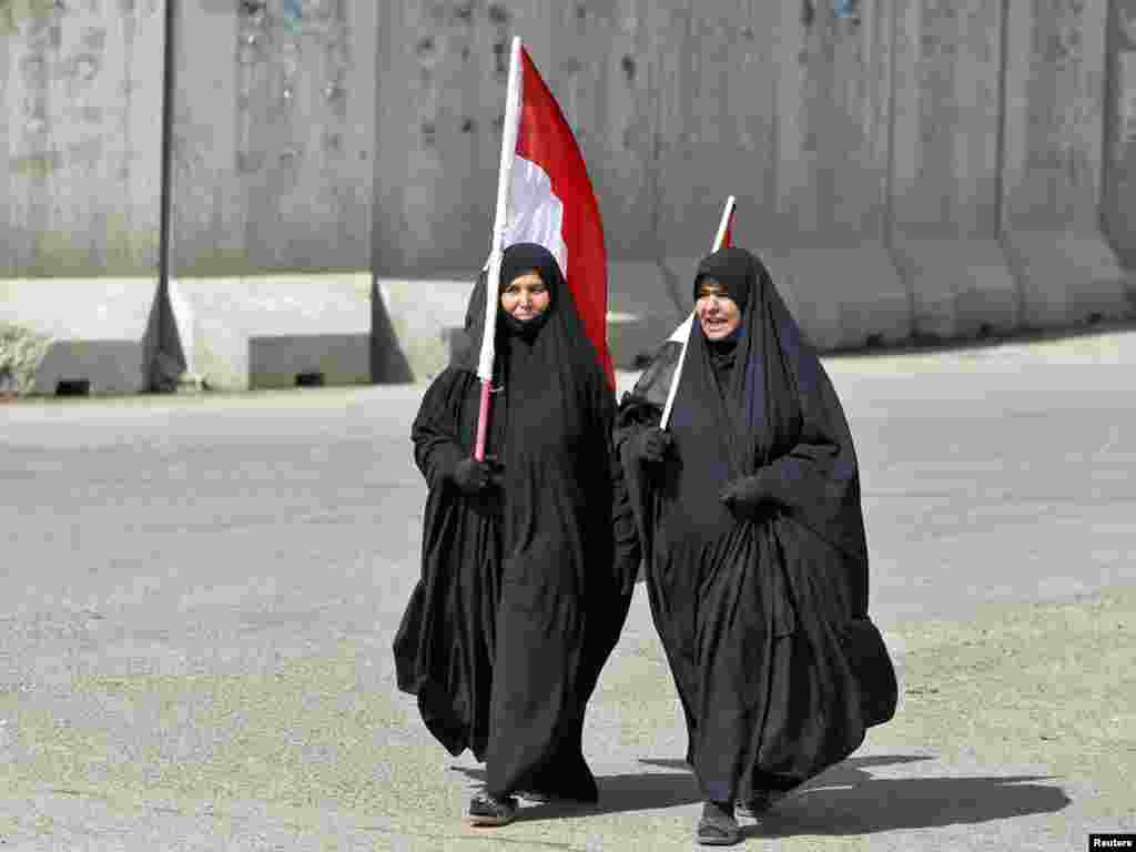 Women carry Iraqi flags toward the "Day of Rage" demonstration in Baghdad.
